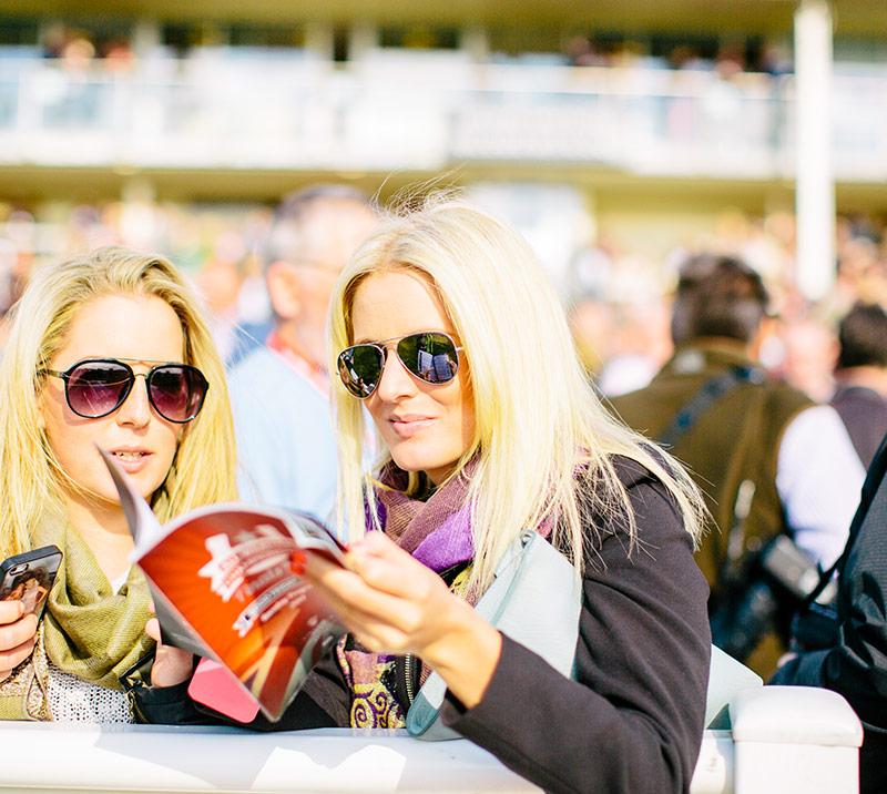two people looking at race programme